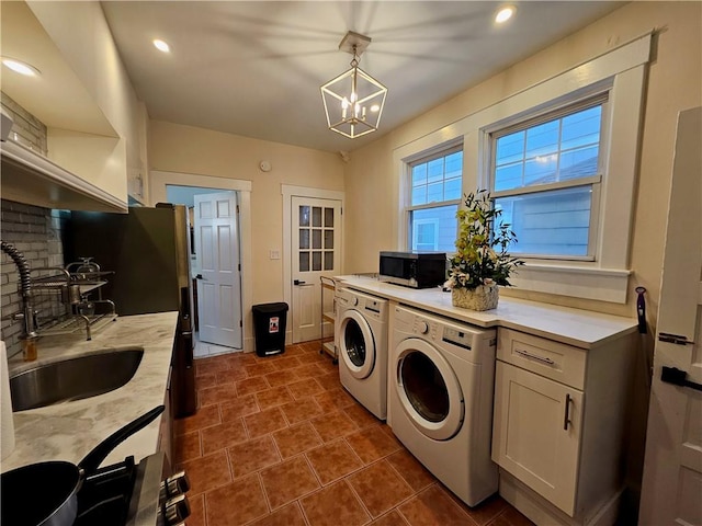 laundry area featuring laundry area, an inviting chandelier, washer and dryer, a sink, and recessed lighting