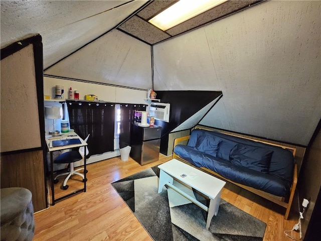 living area featuring wooden walls, lofted ceiling, a wainscoted wall, wood finished floors, and a wall mounted air conditioner