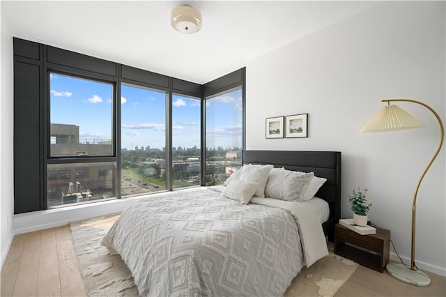 bedroom with light wood-style flooring and baseboards