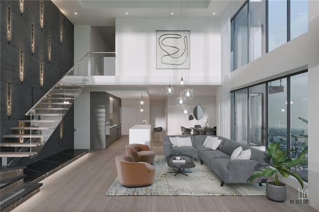 living area featuring a high ceiling, stairway, and light wood-type flooring