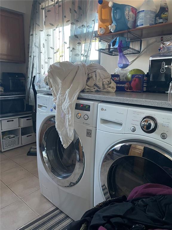 laundry area featuring laundry area, light tile patterned floors, and separate washer and dryer