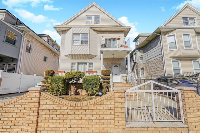 view of front facade featuring a fenced front yard and a balcony