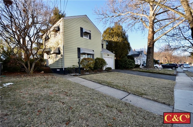 view of home's exterior with aphalt driveway and a yard