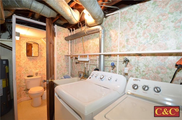 laundry room with water heater, laundry area, washing machine and clothes dryer, and a sink