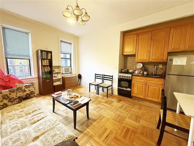 kitchen with sink, backsplash, light parquet flooring, stainless steel refrigerator, and stove