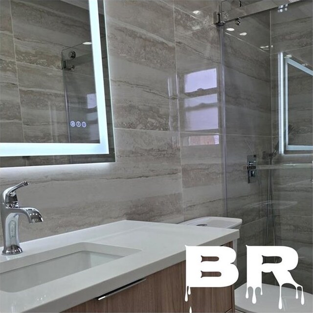 1300 Ave S, Brooklyn, NY 11229 - full bath featuring vanity, a shower stall, and tile walls