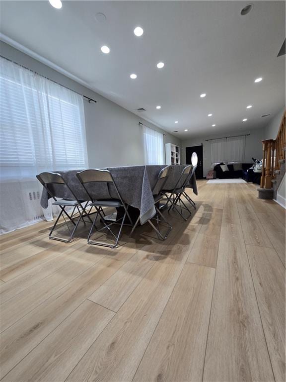 unfurnished dining area featuring light wood finished floors, stairs, and recessed lighting