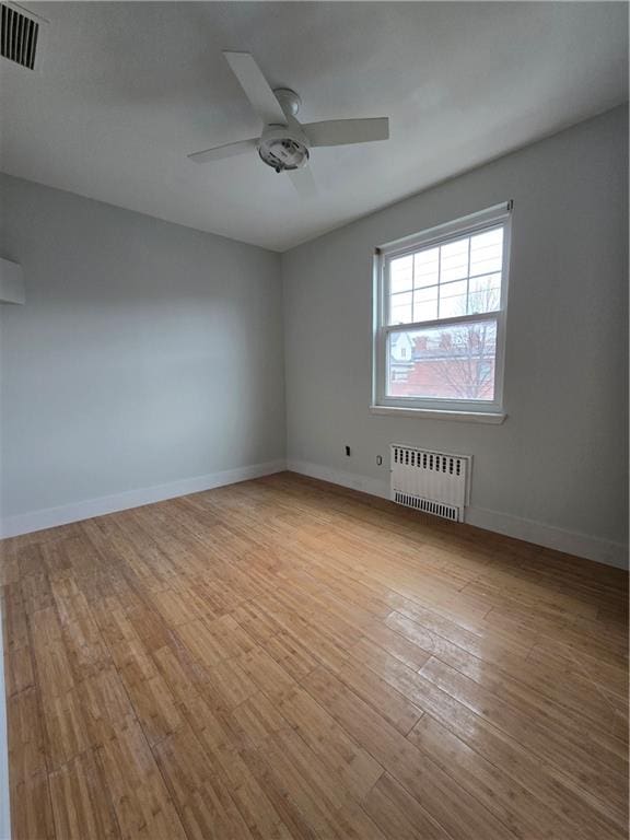 1300 Ave S, Brooklyn, NY 11229 - empty room featuring a ceiling fan, visible vents, wood finished floors, baseboards, and radiator heating unit