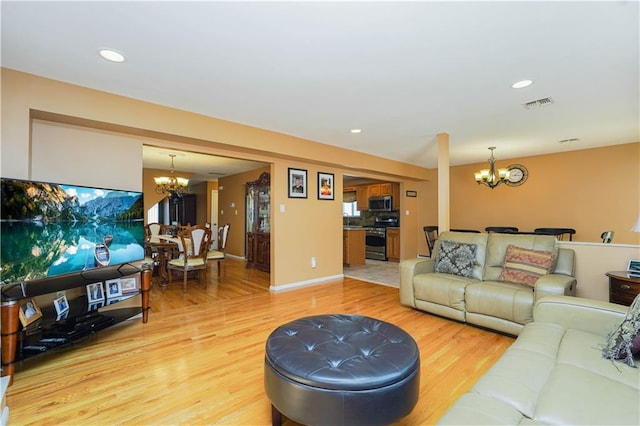 living room featuring recessed lighting, wood finished floors, and an inviting chandelier