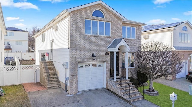 view of front of property with brick siding, concrete driveway, a front lawn, and fence