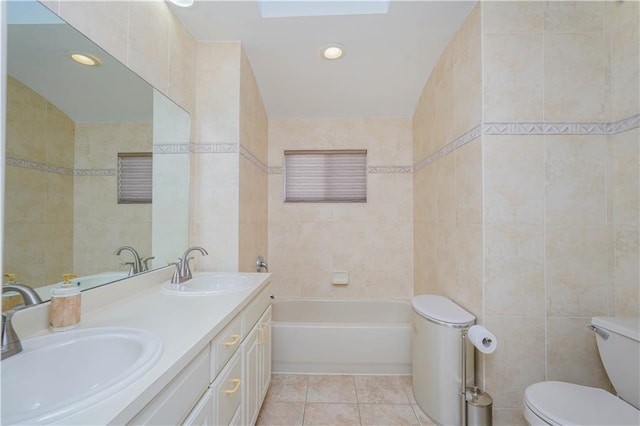 full bathroom with tile patterned flooring, a sink, tile walls, and a bathing tub