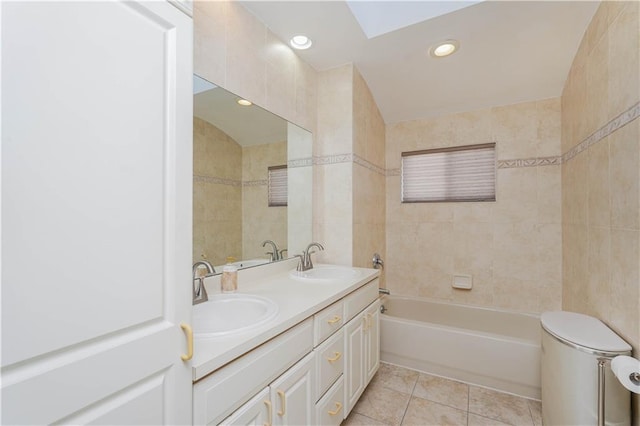 full bath featuring tile patterned flooring, a sink, a bathing tub, and tile walls