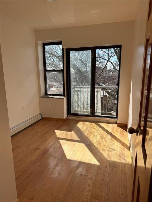 entryway with baseboard heating, wood finished floors, and baseboards