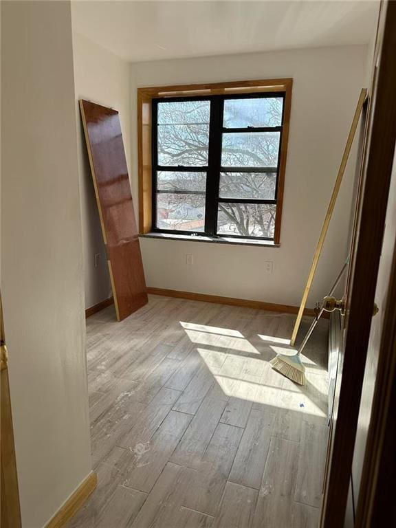 empty room featuring baseboards and wood finished floors