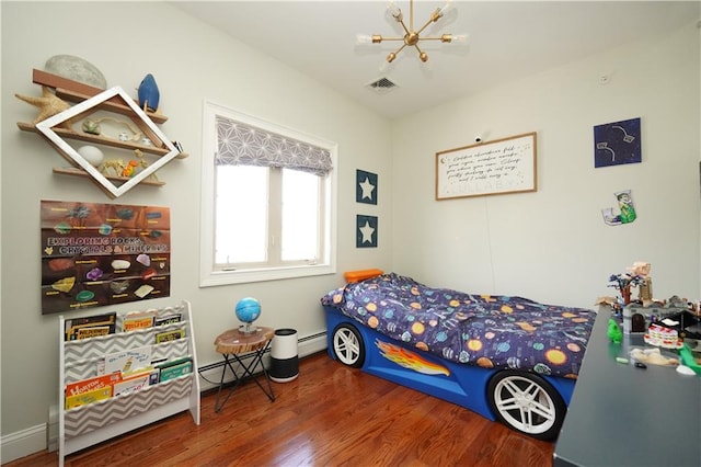 bedroom featuring a baseboard radiator, visible vents, an inviting chandelier, a baseboard heating unit, and wood finished floors