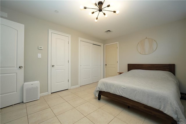 bedroom with a closet, visible vents, baseboards, and light tile patterned flooring