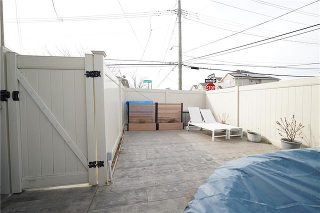 view of patio featuring a gate and fence