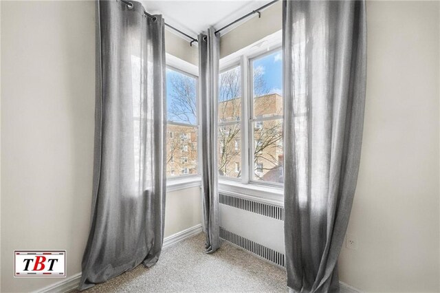 interior space featuring radiator, carpet floors, and baseboards