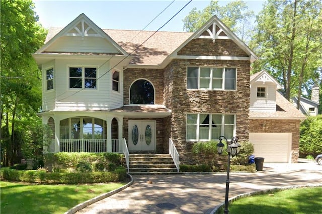 view of front of house with a porch, concrete driveway, and a garage