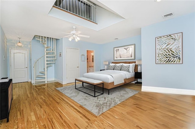 bedroom with ceiling fan, wood finished floors, visible vents, and baseboards