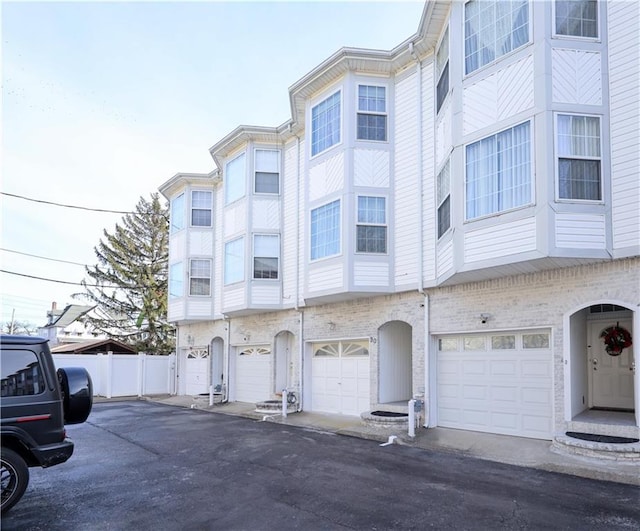 view of building exterior with an attached garage and fence