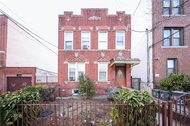 multi unit property featuring a fenced front yard and brick siding