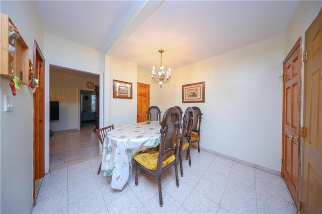 dining area featuring a chandelier, light floors, and baseboards