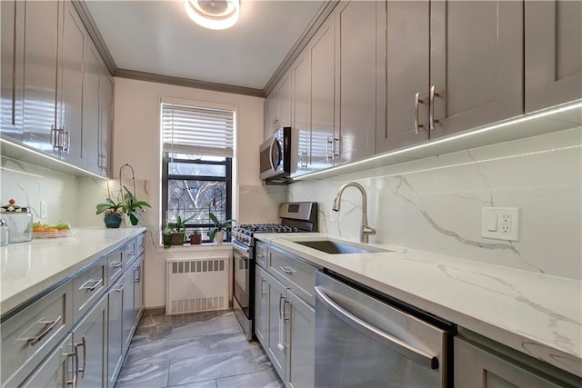 kitchen with stainless steel appliances, a sink, marble finish floor, gray cabinets, and radiator heating unit