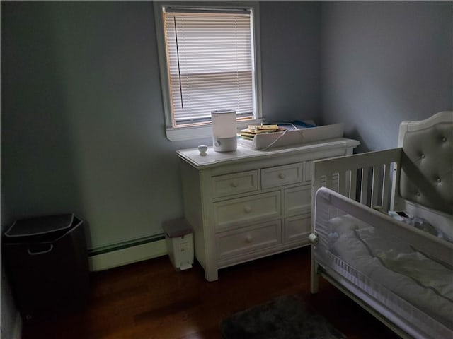 bedroom with a baseboard radiator and dark wood-type flooring