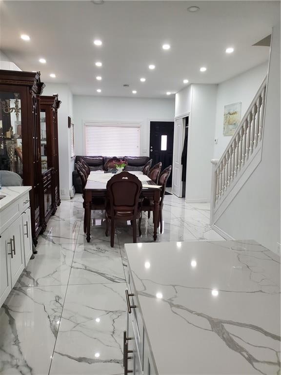 dining space featuring recessed lighting, marble finish floor, and stairway