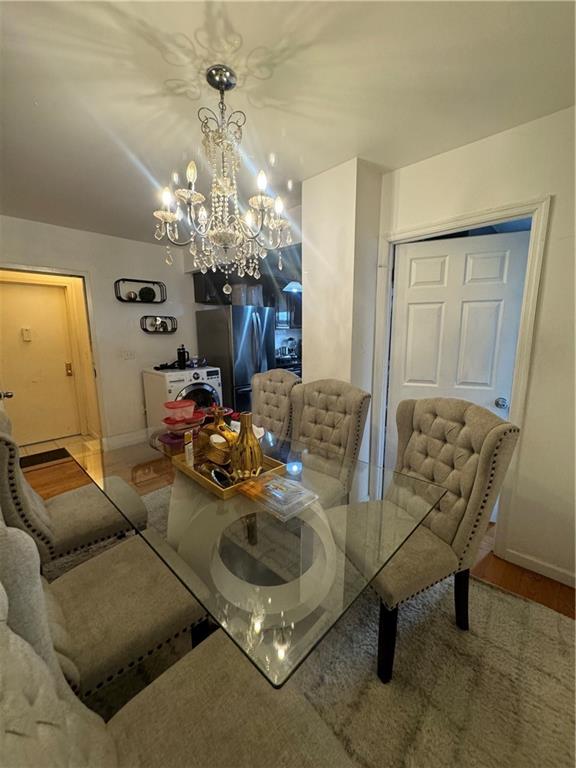 dining room with a notable chandelier, baseboards, and wood finished floors