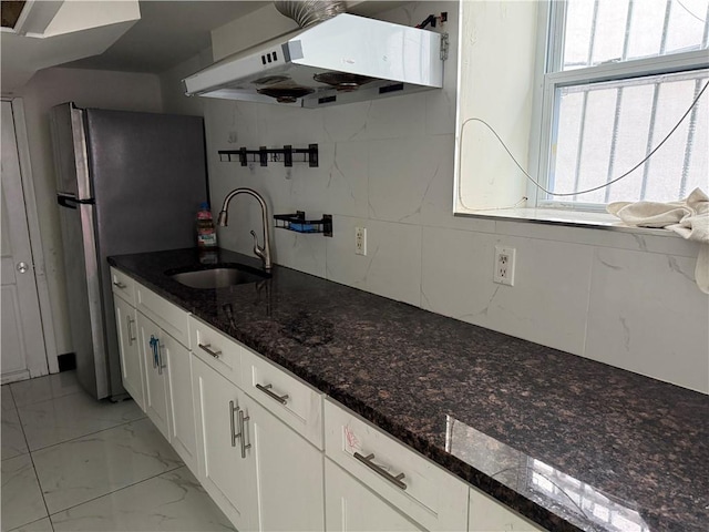 kitchen with marble finish floor, under cabinet range hood, a healthy amount of sunlight, and white cabinets