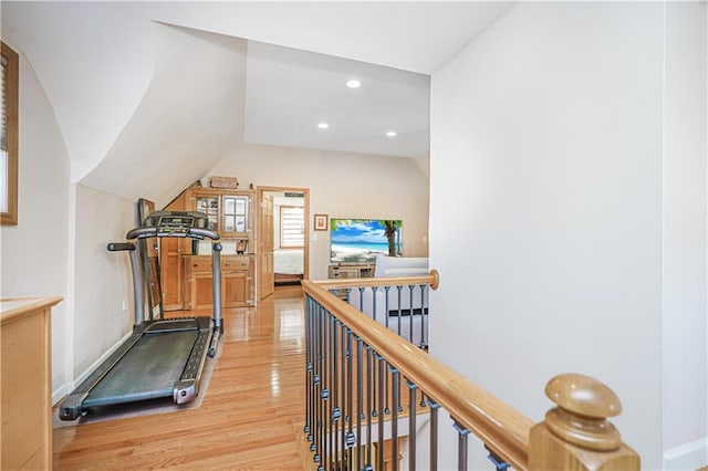 workout area with lofted ceiling, light wood-type flooring, and recessed lighting