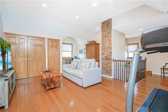 living area featuring recessed lighting, vaulted ceiling, plenty of natural light, and light wood finished floors