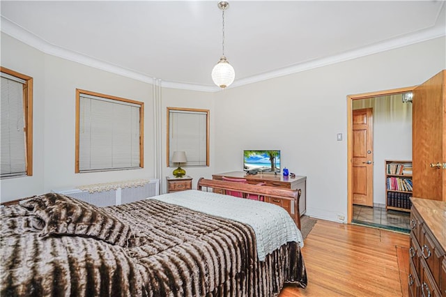 bedroom with ornamental molding and light wood-style flooring