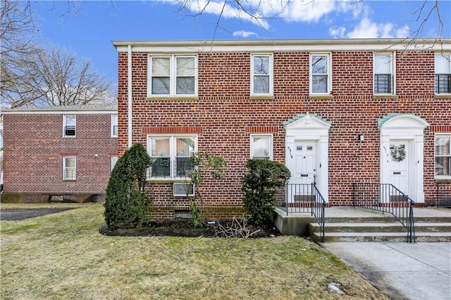 view of front of home with a front lawn and brick siding