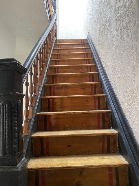 stairway featuring a textured wall