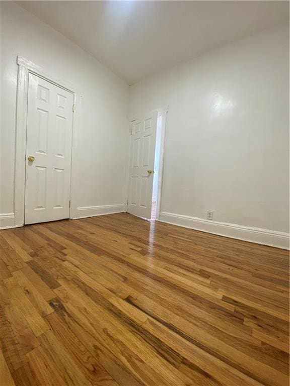 unfurnished room with baseboards and wood finished floors