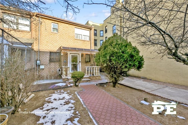 view of front of home featuring a patio area and brick siding