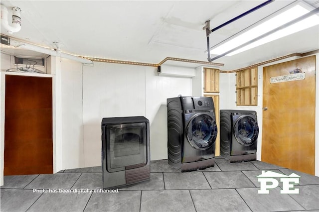 laundry room featuring a garage, tile patterned flooring, laundry area, and separate washer and dryer