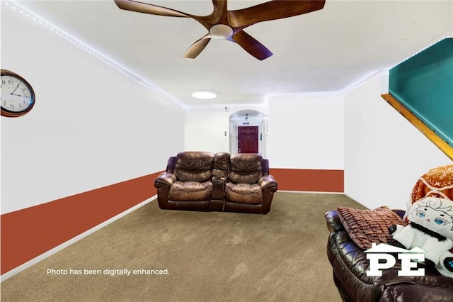 unfurnished living room with a ceiling fan, carpet, crown molding, and arched walkways