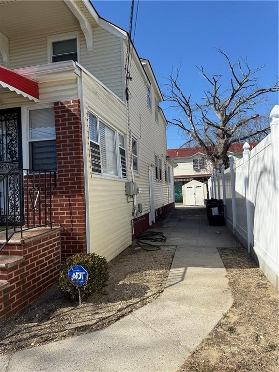 view of property exterior with fence and brick siding