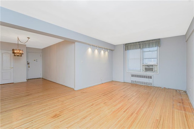 9707 4th Ave Unit 4W, Brooklyn, NY 11209 - unfurnished room featuring radiator, wood finished floors, a chandelier, and cooling unit