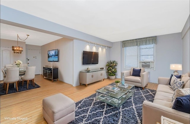 living room with an inviting chandelier and wood finished floors