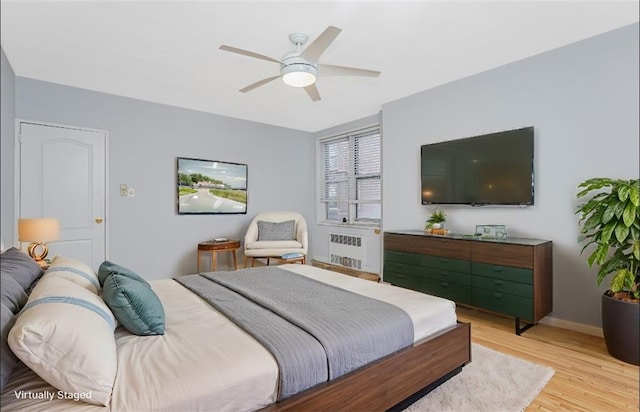 9707 4th Ave Unit 4W, Brooklyn, NY 11209 - bedroom featuring radiator heating unit, light wood-style floors, and a ceiling fan