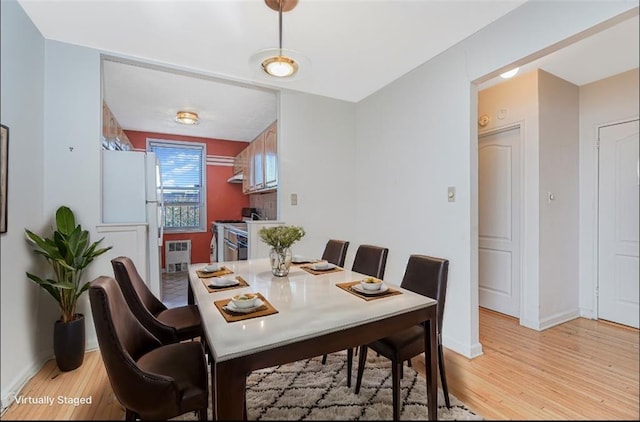 dining room featuring light wood-style flooring and baseboards