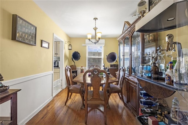 dining area with dark wood-style floors and an inviting chandelier