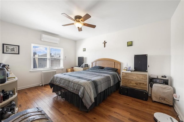 bedroom featuring dark wood-style floors, radiator, ceiling fan, a wall mounted air conditioner, and baseboards