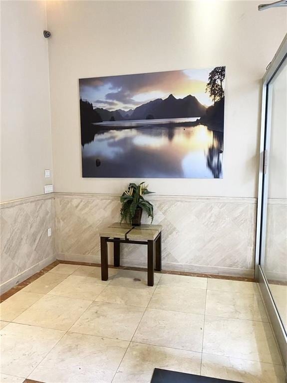 interior space featuring tile patterned flooring and a wainscoted wall