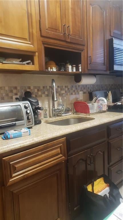 bar featuring backsplash, a sink, and a toaster